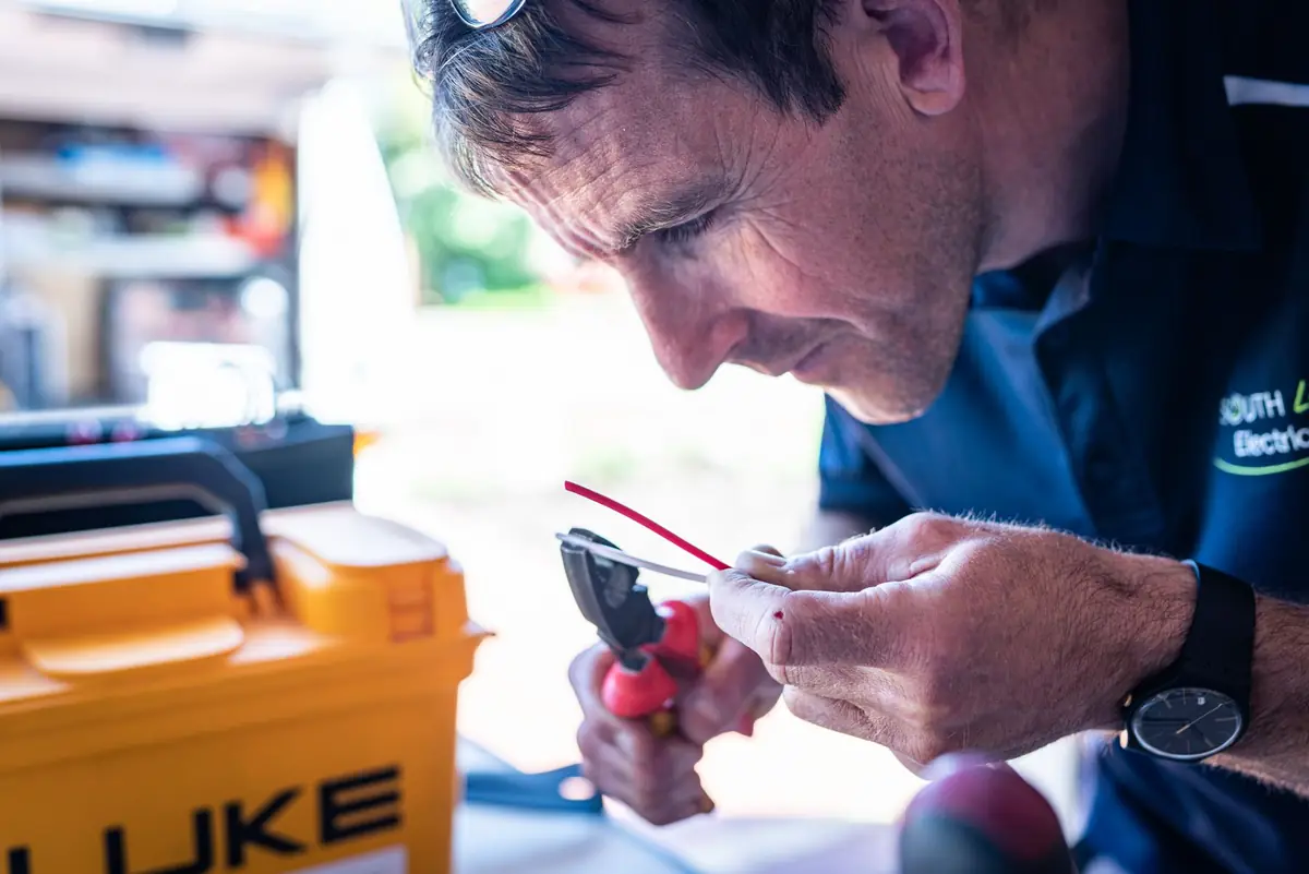 Electrician testing wires with a meter during a home repair